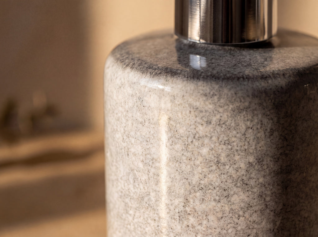 Macro close up of the light heathered grey glaze with fine granite-like mottling and a soft gloss.
