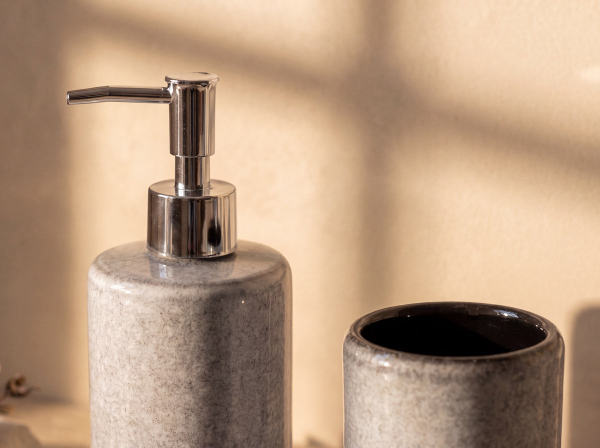 Close up of the chrome pump beside the holder's rim and glossy black interior.