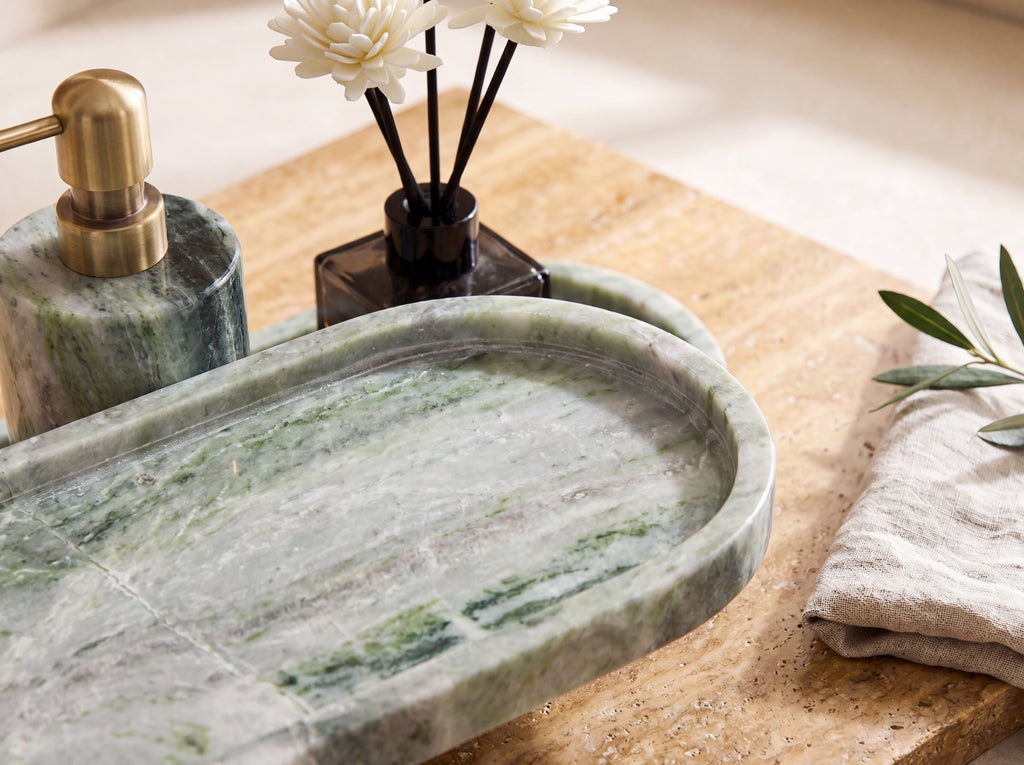 Close-up of an oval emerald marble tray showing green-and-white veining and the low rounded wall.