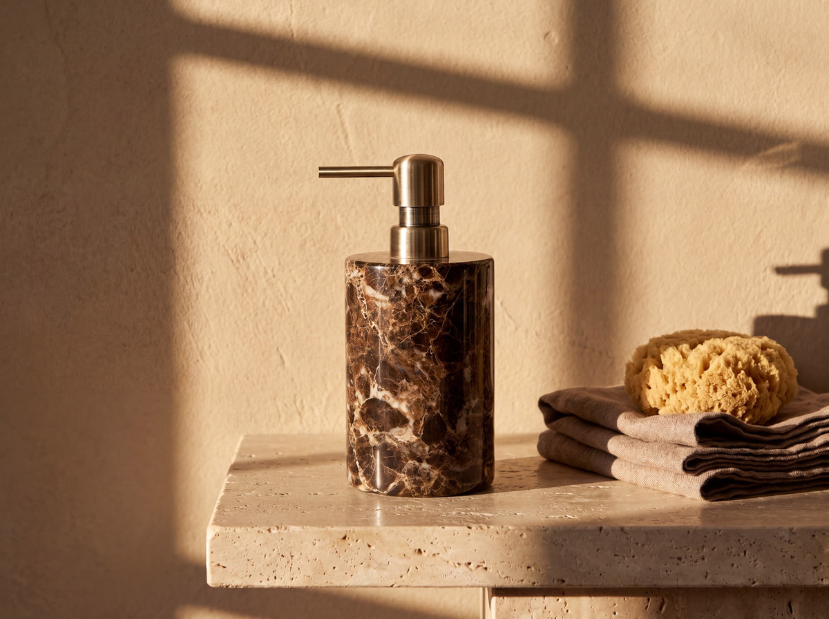 Close-up of the fluted antique brass pump and the glossy white veining running through the dark brown marble beneath it.