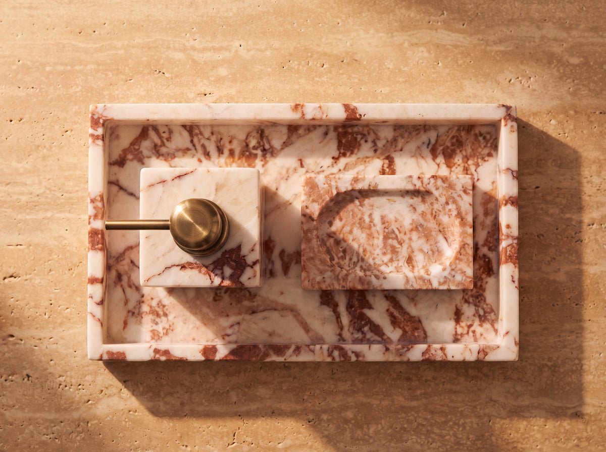 Overhead view of a marble tray holding a marble soap dispenser and a carved marble soap dish with a cream soap bar.