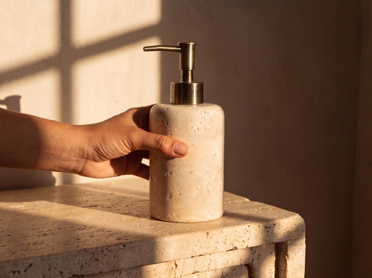 Travertine soap dispenser held in a woman's hand to show its real size at 17 cm tall