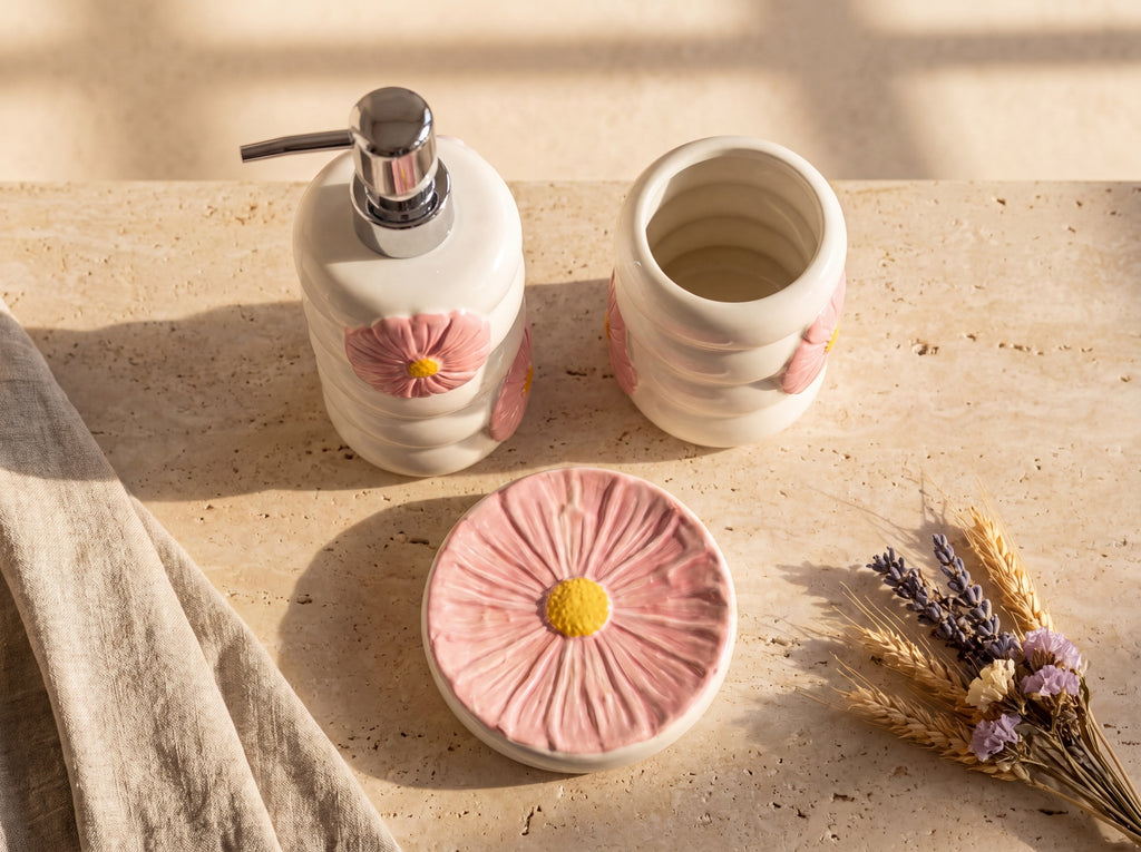 High-angle view of the 3-piece set: dispenser, open-top holder and a soap dish shaped like a pink flower.