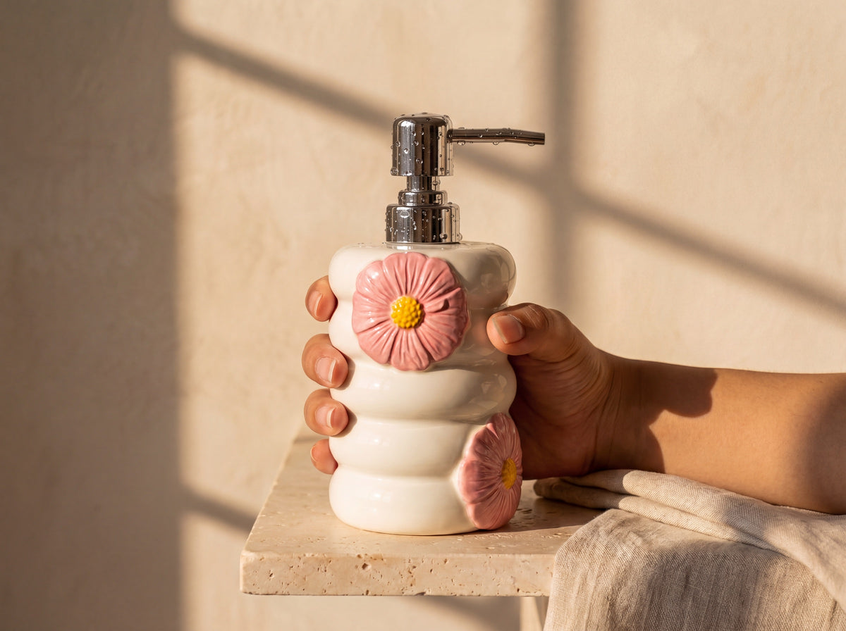 A hand holding the 18 cm porcelain soap dispenser to show its size.
