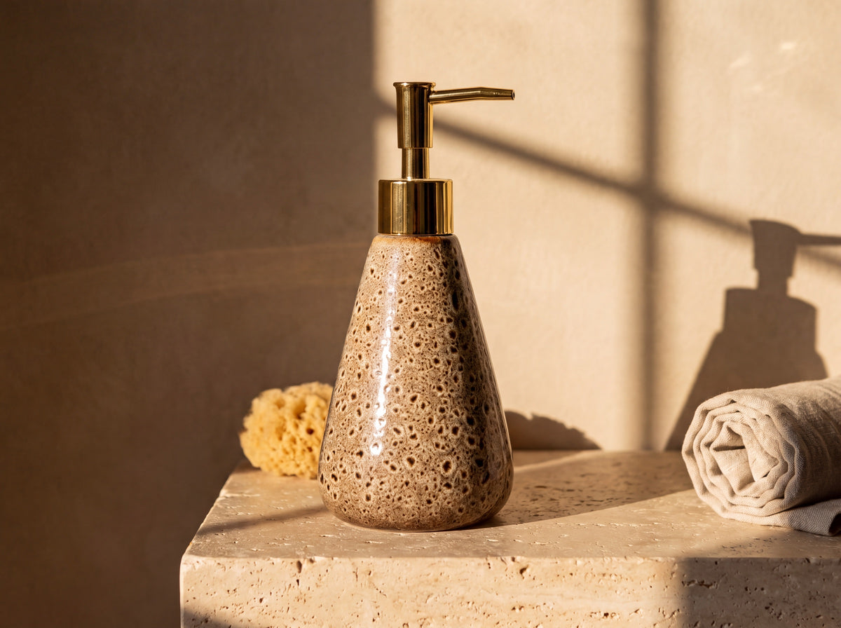 Three-quarter view of the glossy speckled ceramic dispenser with sunlight highlighting the glaze.