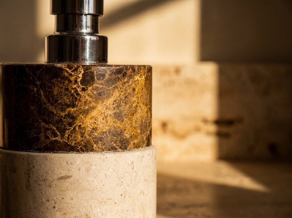 Close-up of golden veining where dark emperador marble meets cream marble on a soap dispenser.